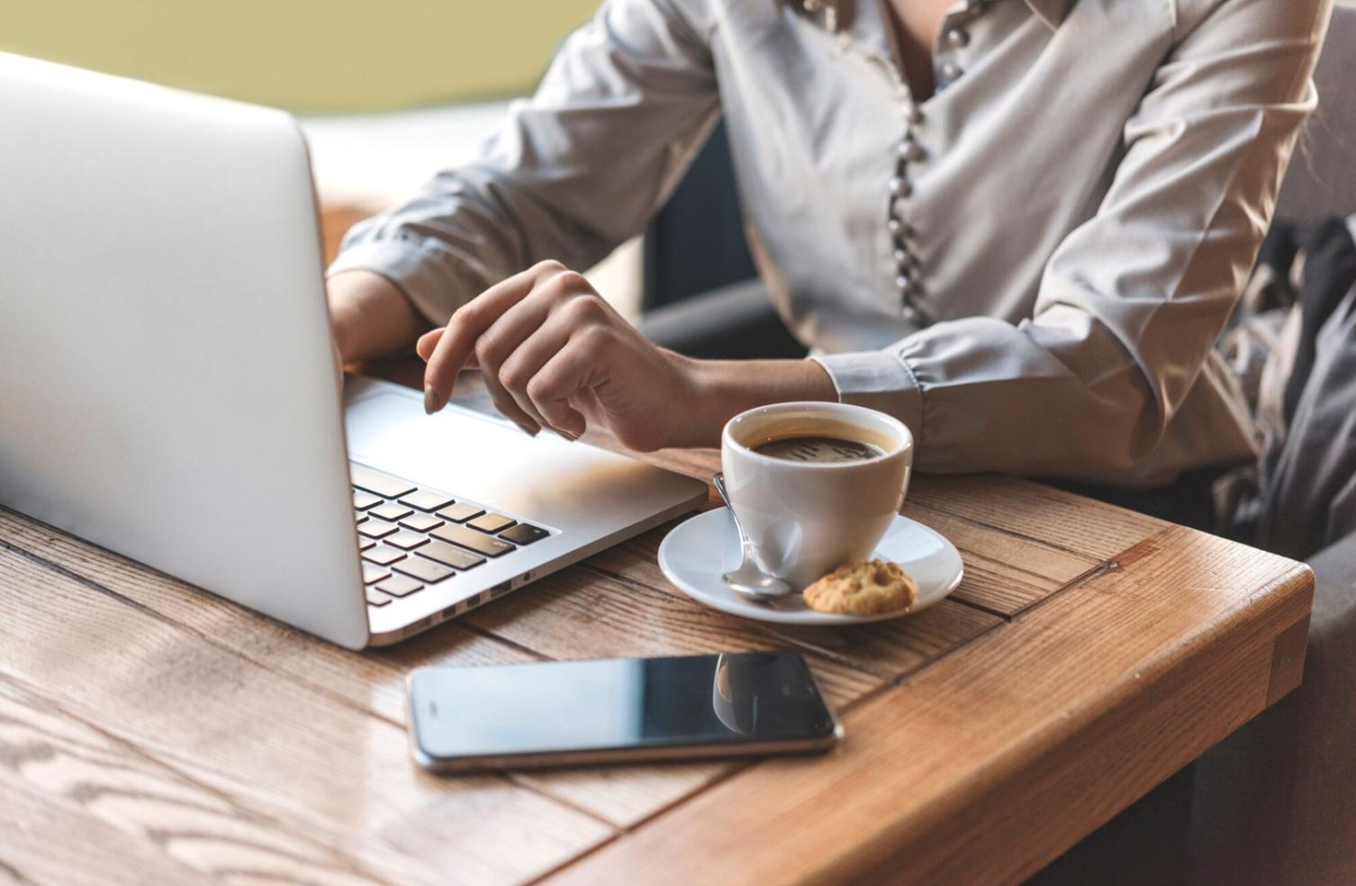 Beratungsgespräch mit Finanzunterlagen und Laptop auf modernem Schreibtisch